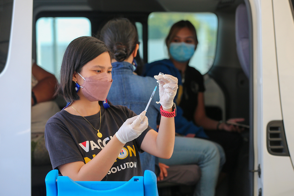 Members of the Manila Health Department (MHD) administer COVID-19 vaccine at the Quirino Grandstand Drive-thru vaccination site in Manila on Jan. 17, 2022. Jonathan Cellona, ABS-CBN News/File
