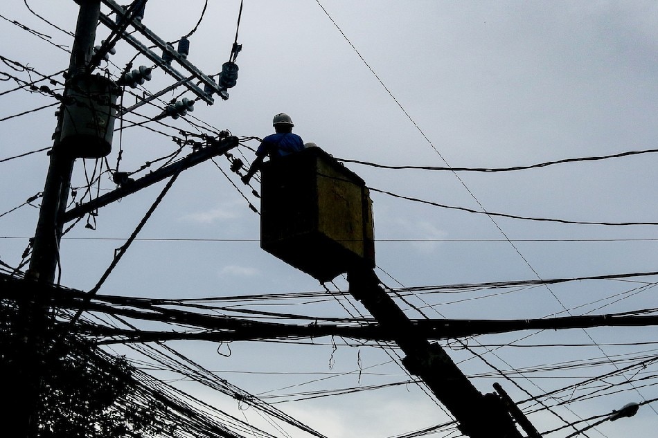 Linemen work on electrical posts at a street in Mandaluyong on Sept. 15, 2021. George Calvelo, ABS-CBN News
