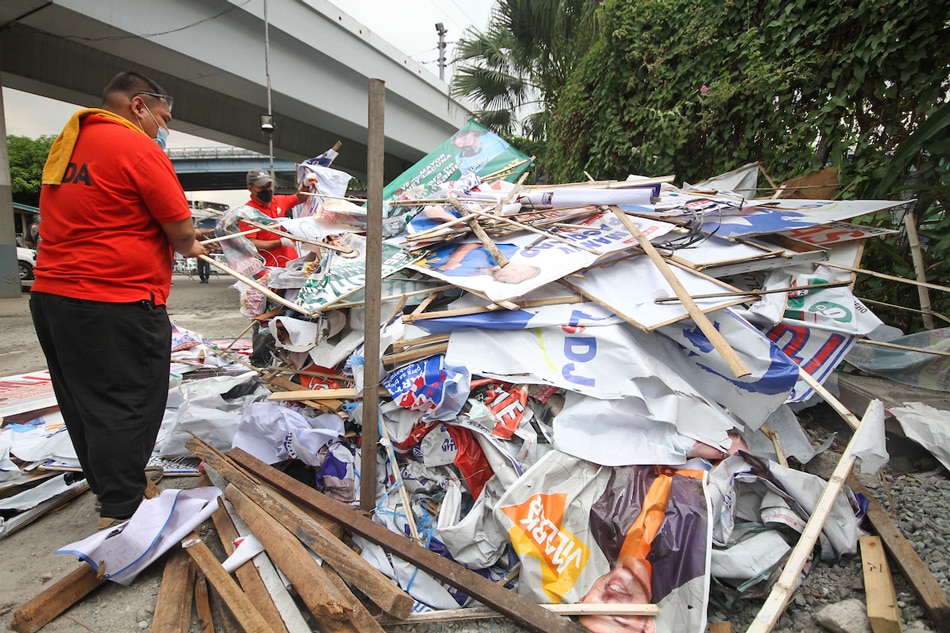 Members of the Metro Manila Development Authority collect dismantled campaign posters and tarpaulins at the MMDA satellite office in Sta. Mesa, Manila after they carried out 'Oplan Baklas' on Feb. 18, 2022. The Commission on Elections came under fire after several videos of its enforcers dismantling campaign materials in private properties went viral on social media, with some describing the incidents as 