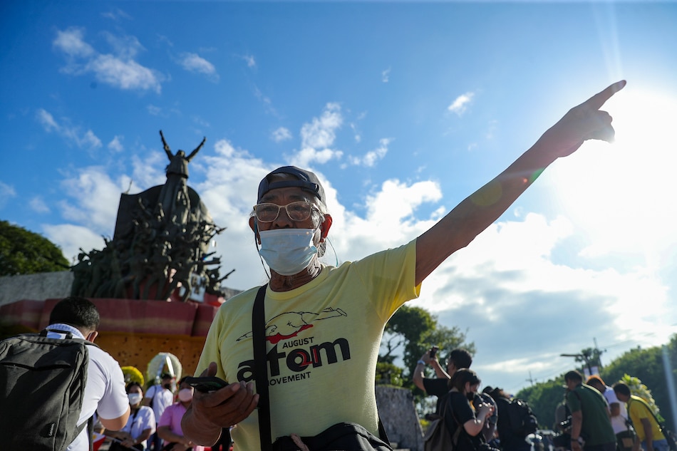 Edgardo Mercader, who joined the EDSA People Power revolution in 1986, visits the People Power Monument on Feb. 25, 2022 wearing the ATOM or August Twenty-one Movement shirt he wore 36 years ago. Jonathan Cellona, ABS-CBN News