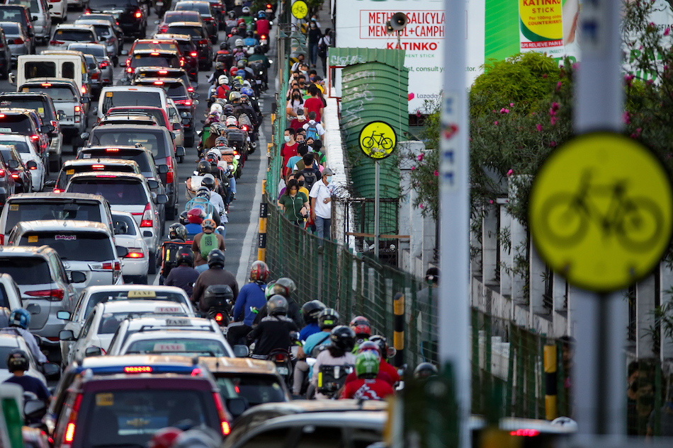 Pedestrians pass through a heavily congested EDSA traffic in Makati City on February 24, 2022. George Calvelo, ABS-CBN News