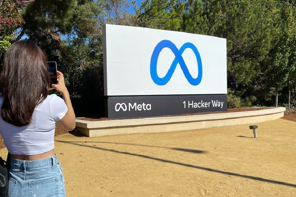 A visitor takes picture of billboard sign featuring a new logo and name 'Meta' in front of Facebook headquarters in Menlo Park, California, USA, 29 October 2021. John Mabanglo/EPA-EFE/File