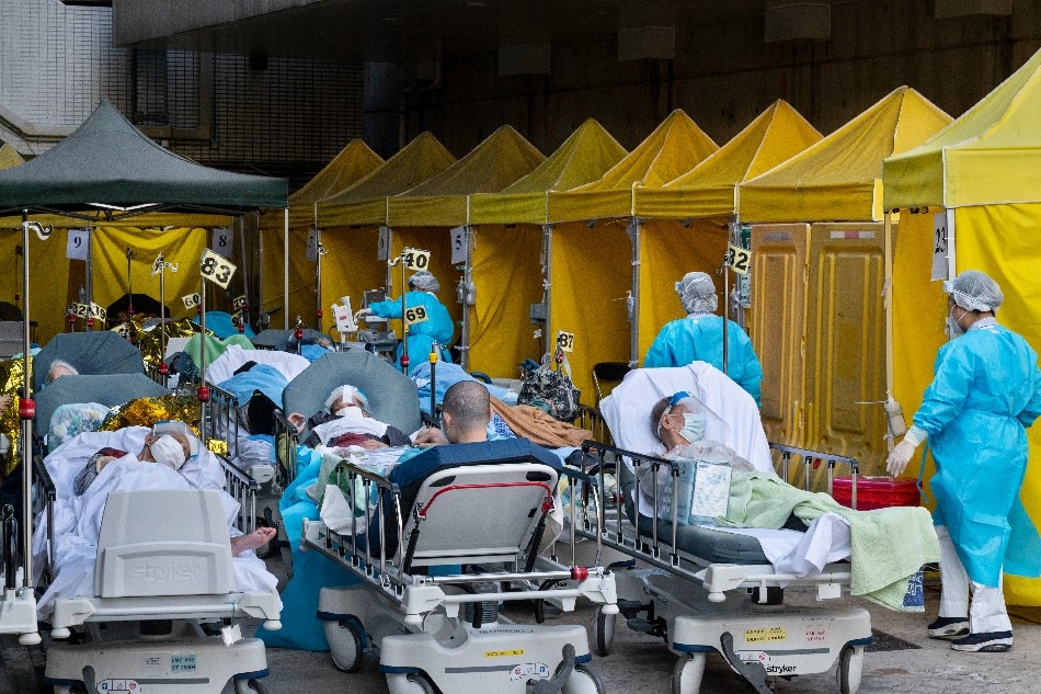 Patients showing COVID-19 symptoms lie on beds outside the Accident and Emergency Department at Caritas Medical Center in Hong Kong, China, Feb. 15, 2022. Hong Kong's medical system has been overloaded by the fifth-wave COVID-19 outbreak while authorities have reported more than 1,600 confirmed cases and 5,400 suspected infections on Feb. 15. Miguel Candela, EPA-EFE