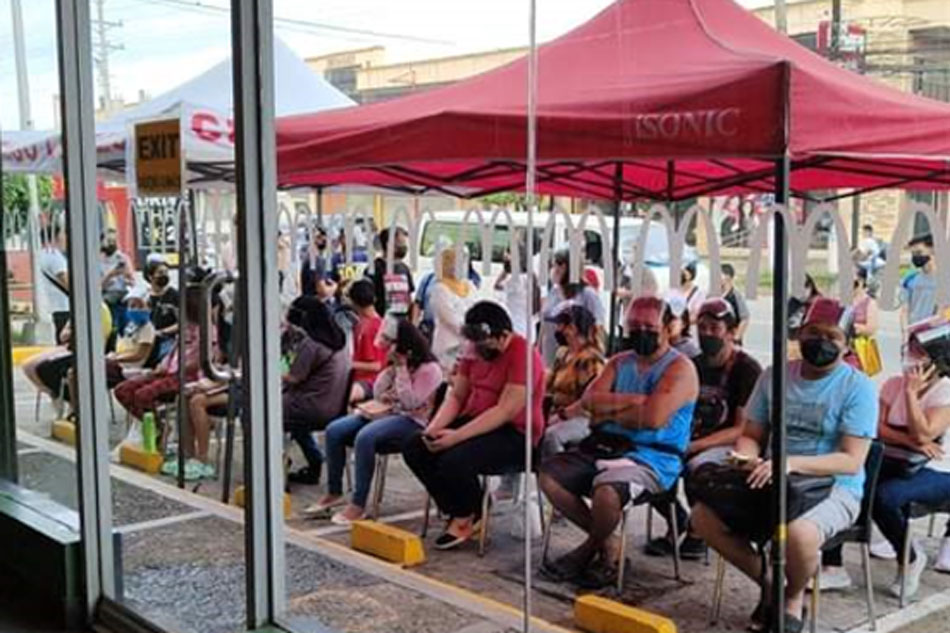 Vaccine recipients seen waiting outside a McDonald’s store during the third National Vaccination. Handout