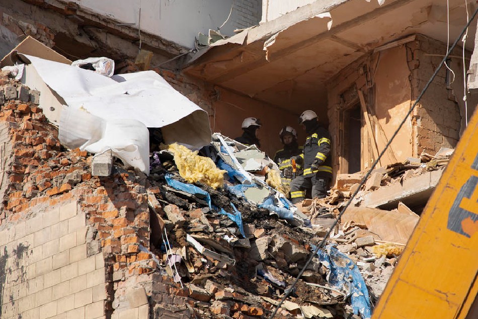 Ukrainian firefighters work inside a damaged building in the aftermath of a shelling in Kharkiv, Ukraine, March 13, 2022. The city of Kharkiv, Ukraine