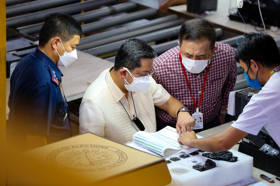 Commission on Elections (COMELEC) Chairman Saidamen Pangarungan (right) and Commissioner George Garcia inspect the work at the assembly line of Vote Counting Machines (VCMs) at their warehouse in Sta. Rosa, Laguna on March 14, 2022. Jonathan Cellona, ABS-CBN News/FILE