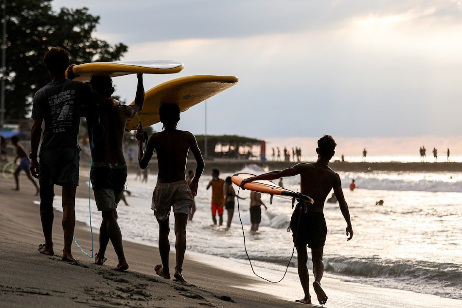 People carry surf boards as they walk along the beach in San Juan, La Union amid the COVID-19 pandemic. Basilio H. Sepe, ABS-CBN News/file