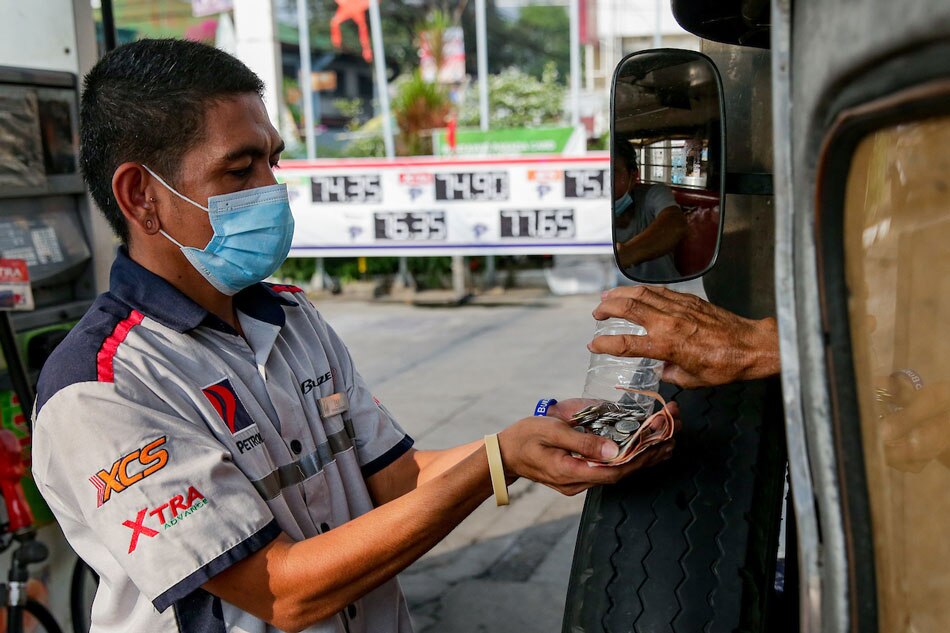 A gas station clerk receives a jeepney driver’s payment in coins at a station in Manila on March 15, 2022. Motorists and commuters continue to struggle as oil prices continue to skyrocket. George Calvelo, ABS-CBN News