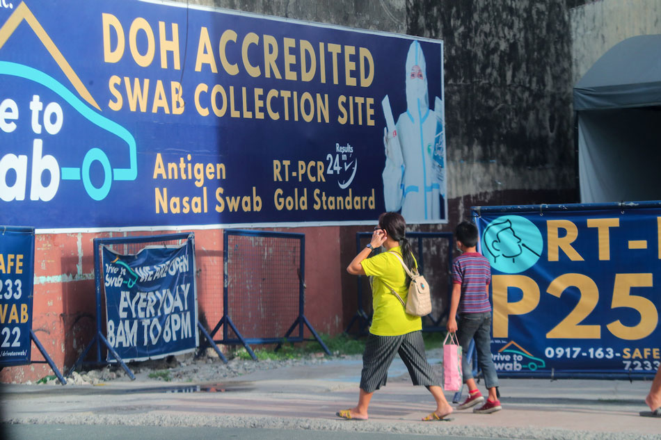 People walk beside a privately run COVID-19 testing center along Kamuning Avenue in Quezon City on March 17, 2022. Jonathan Cellona, ABS-CBN News/file