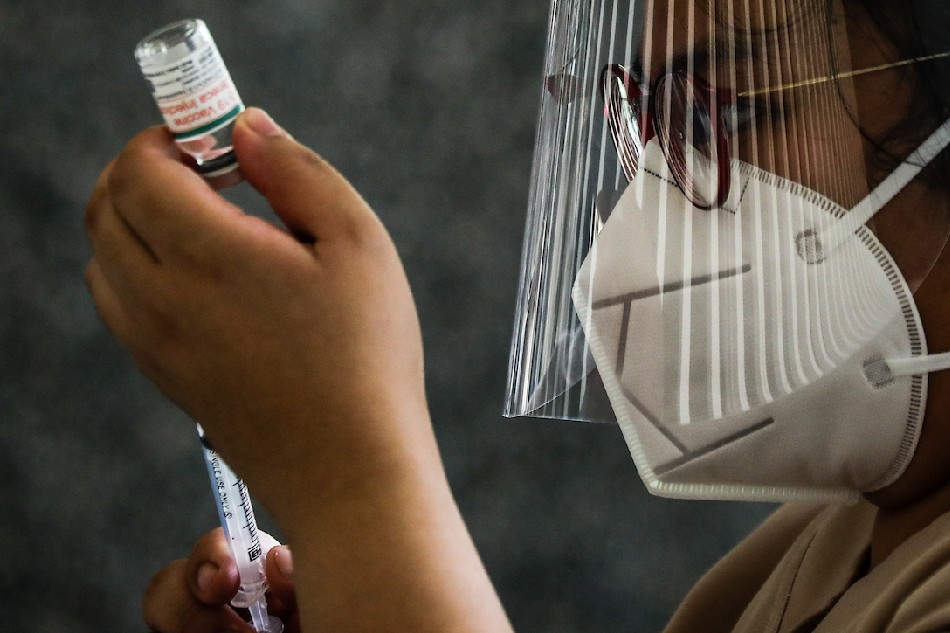 A health worker prepares as residents queue to receive their second dose of AstraZeneca COVID-19 jabs at the Immaculate Heart of Mary Parish in Quezon City on Aug. 13, 2021. Jire Carreon, ABS-CBN News