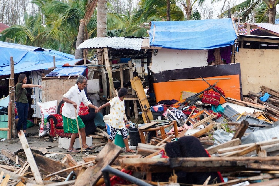 Residents walk near damaged homes in the coastal town of Tubigon, Bohol, one of the hardest hit provinces of typhoon Odette on Dec. 28, 2021. Aica Dioquino, OVP handout/File 