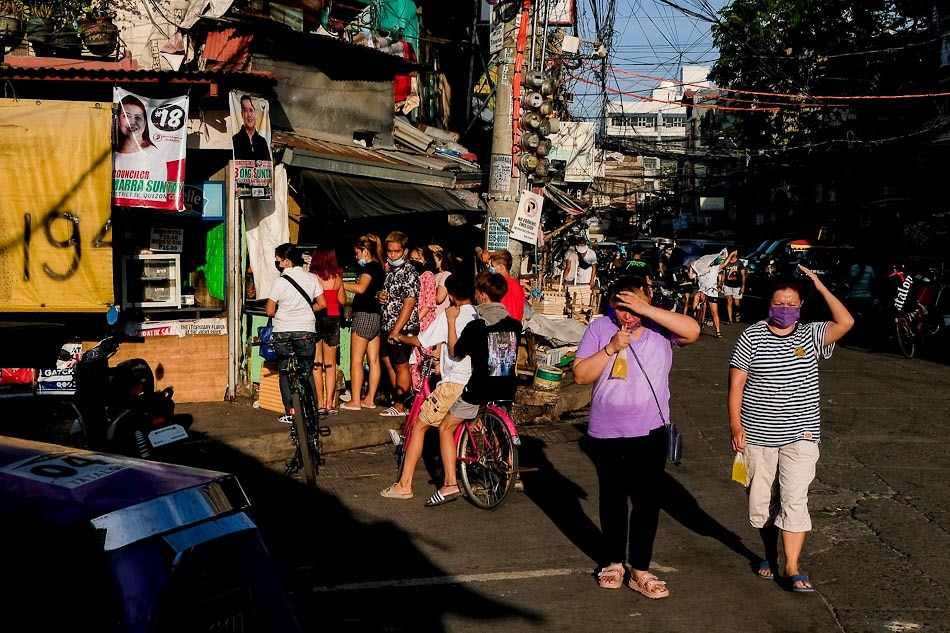 People walk under the afternoon heat in Quezon City on March 23, 2022. George Calvelo, ABS-CBN News/file