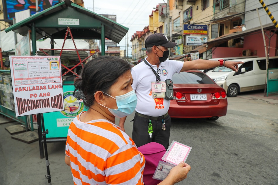Barangay volunteers screen people entering Barangay 183 in Pasay City on Jan. 13, 2022. Jonathan Cellona, ABS-CBN News/File 