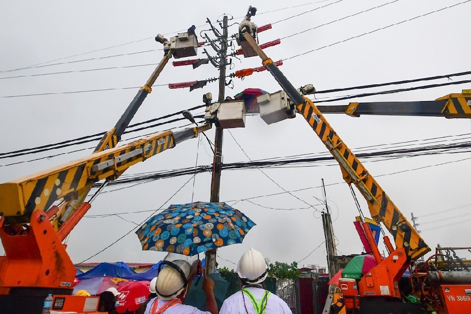 Pag-aayos ng isang power line ng Meralco sa Quezon City noong Abril 5, sa gitna ng pag-ulan. Mark Demayo, ABS-CBN News/File