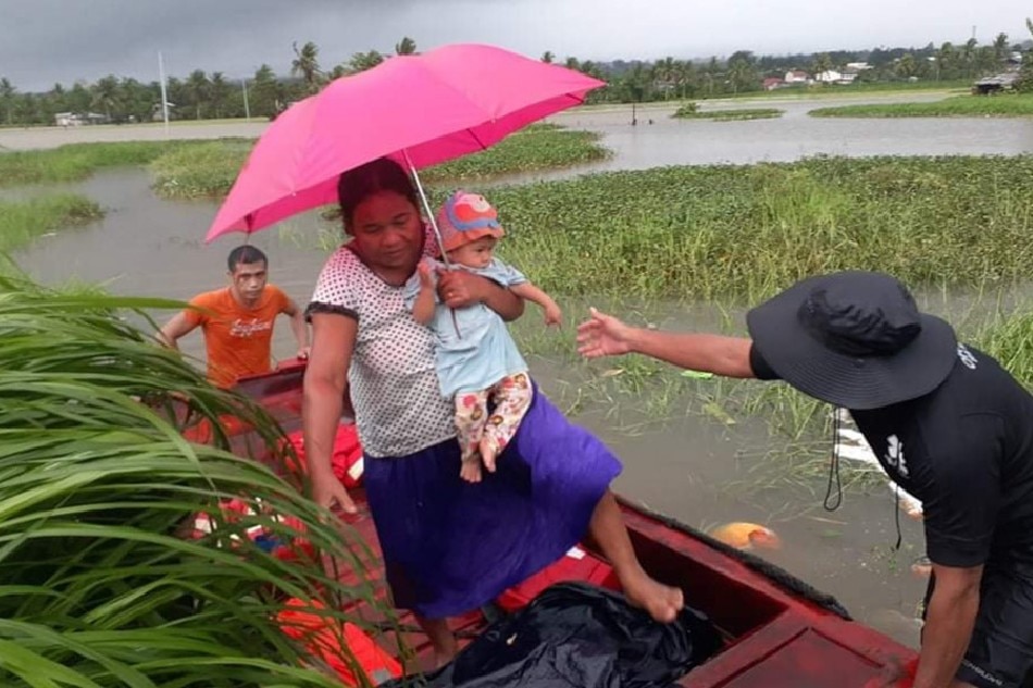 Members of the Philippine National Police and City Disaster Risk Reduction and Management Office rescue residents of Barangay Isidro, Ormoc City on Sunday as Tropical Storm Agaton caused flooding in the area. Photo couretsy of Glenn Vergara