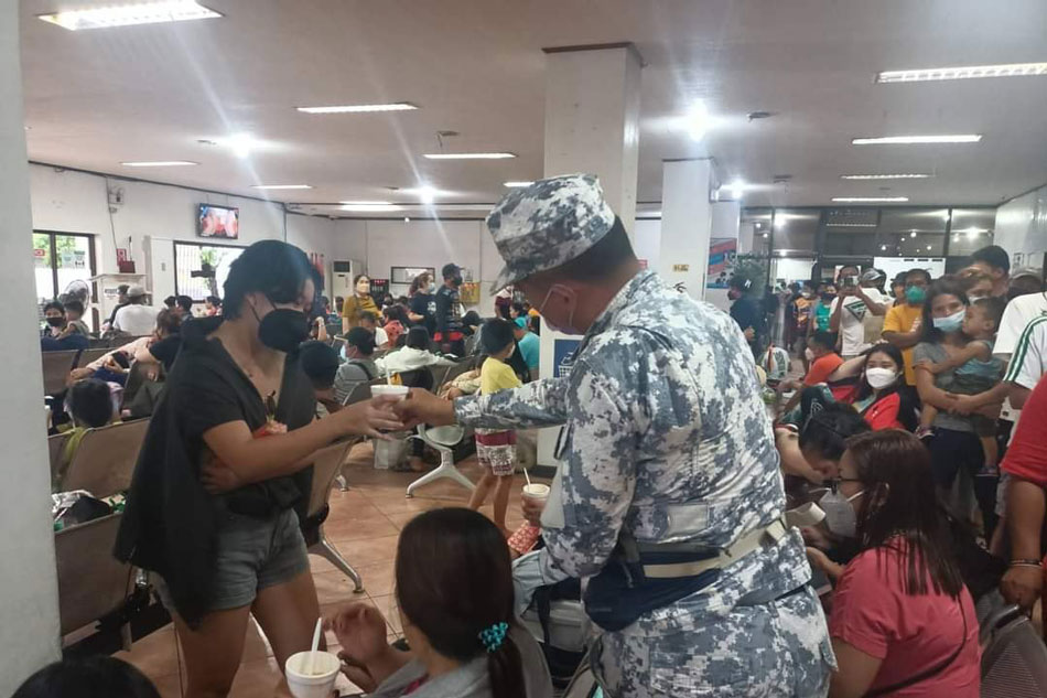 Philippine Coast Guard personnel distribute food to stranded passengers, drivers, and cargo helpers at the Matnog Port in Sorsogon, April 11, 2022. PCG Facebook page