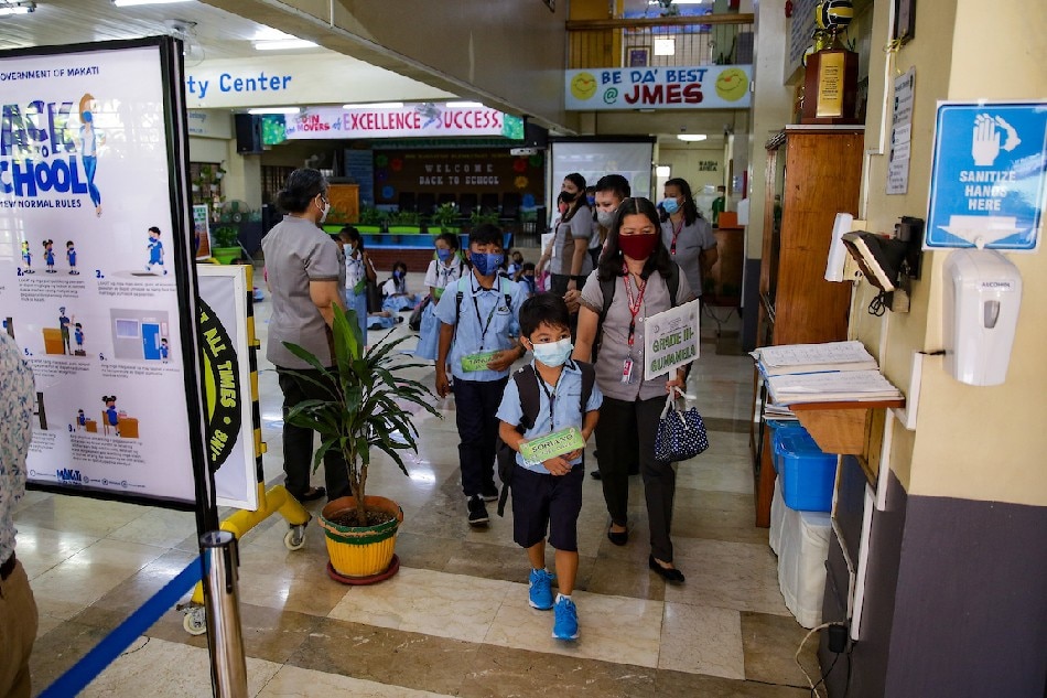 Students prepare to enter their respective classrooms at the Jose Magsaysay Elementary School in Makati City on March 30, 2022.