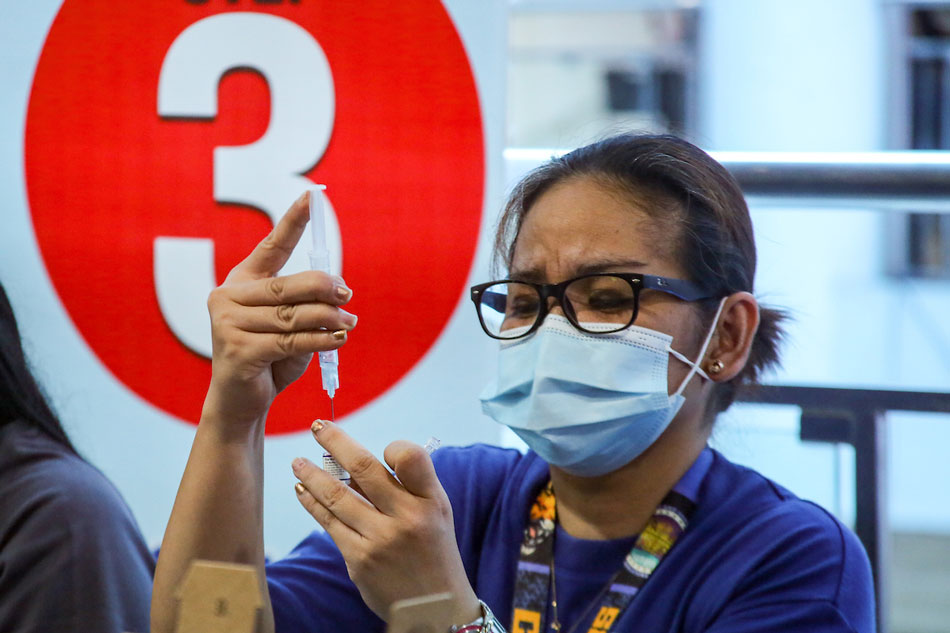 A health worker prepares a COVID-19 shot at the Mandaluyong City Hall on April 19, 2022. Jonathan Cellona, ABS-CBN News