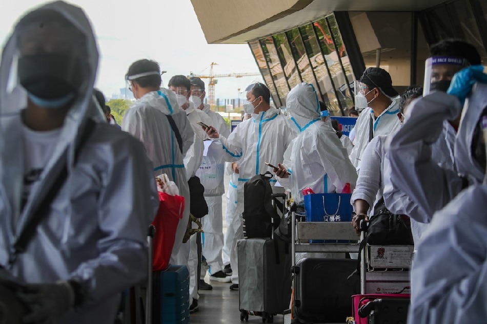 Overseas workers and travelers, many of whom wear personal protective suits, line up at the Terminal 1 Departure area at the Ninoy Aquino International Airport (NAIA) on April 7, 2022. Jonathan Cellona, ABS-CBN News
