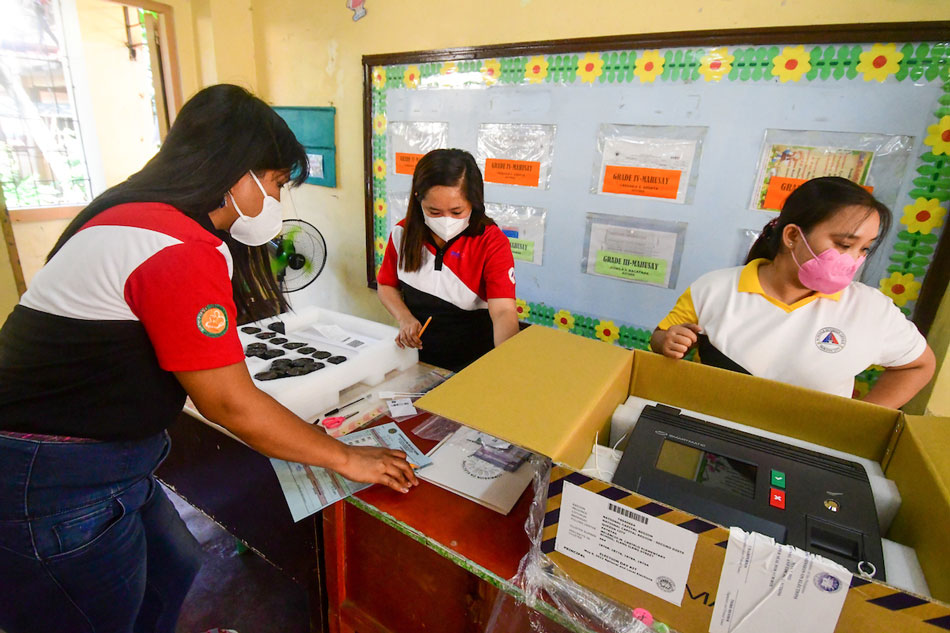 Members of the Electoral Board and poll watchers conduct their final testing and sealing of vote counting machines at Melencio M. Castelo Elementary School in Quezon City on Tuesday, six days before the national elections. Around 65.7 million domestic voters are expected to cast their votes for national and local candidates. Mark Demayo, ABS-CBN News