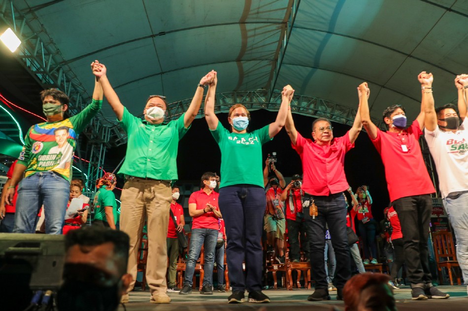 Narvacan, Ilocos Sur Mayor Luis Chavit Singson raises the hands of presidential aspirant Ferdinand 'Bongbong' Marcos Jr. and his running mate Davao City Mayor Sara Duterte-Carpio during a campaign sortie in Narvacan, Ilocos Sur on February 17, 2022. Jonathan Cellona, ABS-CBN News.