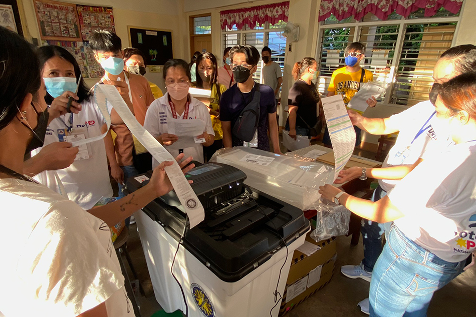 Electoral board officers initiate the VCM to start the voting process at Precinct 1055 at Tomas Morato Elementary School in Quezon City on May 9, 2022. Fernando G. Sepe Jr., ABS-CBN News