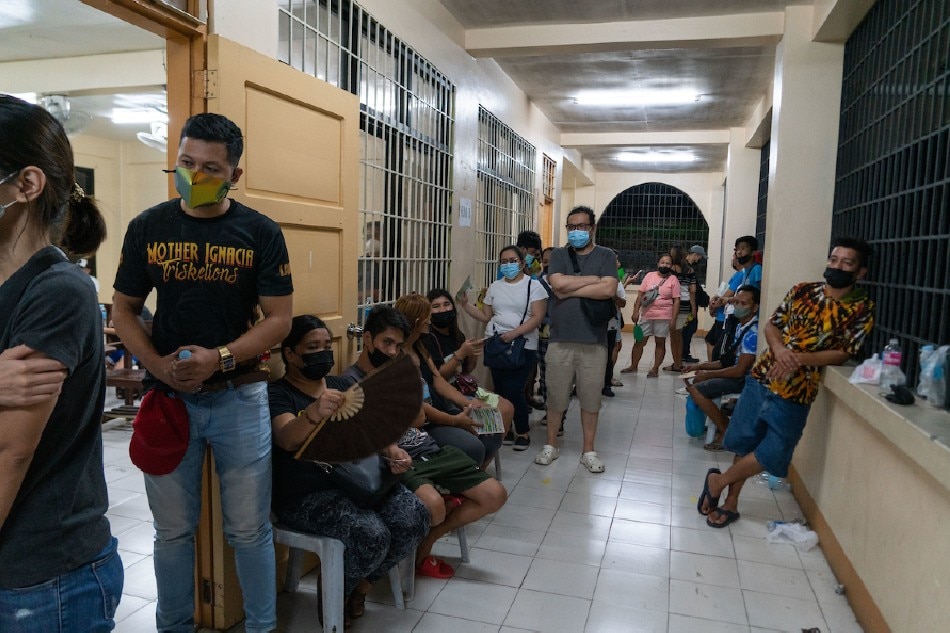 Voters line up to cast their votes at 9PM, after a VCM malfunction at the Barangay Hall of Barangay Valencia, Quezon City on May 9, 2022. Residents waited for the VCM replacement, which malfunctioned at the opening of the polling precincts at around 8PM. Gigie Cruz, ABS-CBN News