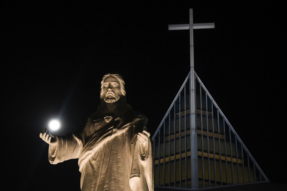 A day after the super worm moon equinox treated Manila sky gazers, the moon still cuts brightly through the night as it sits backdropped against the statue of Jesus Christ at the Church of the Gesú at the Ateneo de Manila University on March 21, 2019. Mark Demayo, ABS-CBN News