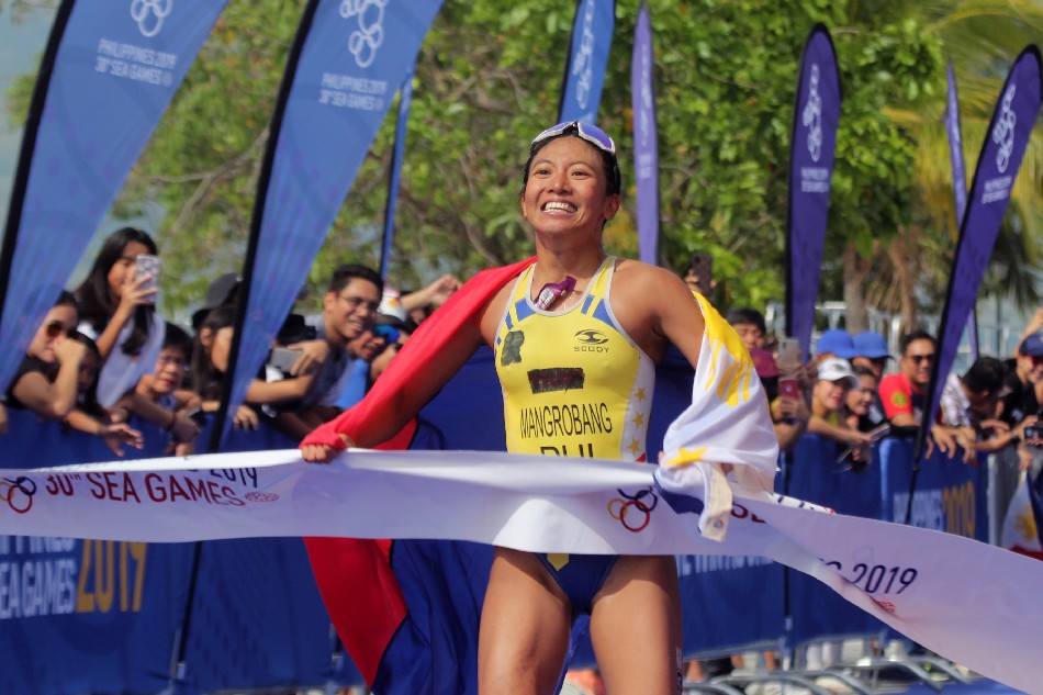 Filipino athlete Marion Kim Mangrobang celebrates as she crosses the finish line to win the gold medal for the Women’s triathlon event at the 30th South East Asian Games in Subic Bay Freeport zone, Philippines, 01 Decemeber 2019. File photo. Jun Dumaguing, EPA-EFE/File.