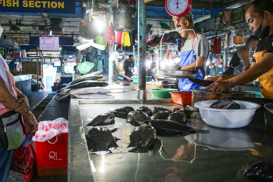 A resident buys fish at a wet market in Taguig City on April 11, 2022. Jonathan Cellona, ABS-CBN News/file