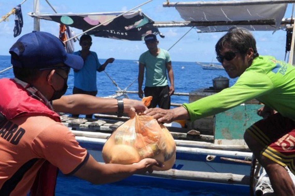 The Philippine Coast Guard distributes relief supplies and COVID-19 kits to fishermen on Pag-asa Island. Photo courtesy of Philippine Coast Guard/Facebook