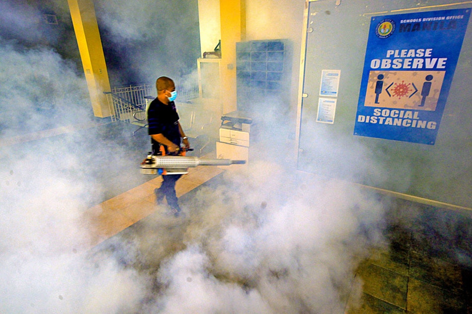 A worker from the Manila Disaster and Risk Reduction Management Office (MDRRMO) conducts fumigation at the Department of Education building in Arroceros, Manila on May 29, 2022 after the health department recorded a rise in dengue cases around the country. ABS-CBN News/File