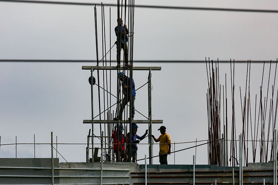 Workers are seen on top of a construction site in Pasig City on May 27, 2022. George Calvelo, ABS-CBN News/File