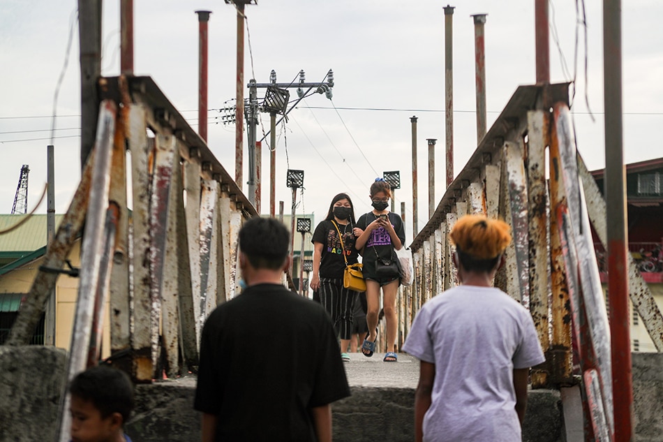 People wearing face masks as a precaution against COVID-19 cross a bridge in Navotas City on February 02, 2022. Jonathan Cellona, ABS-CBN News