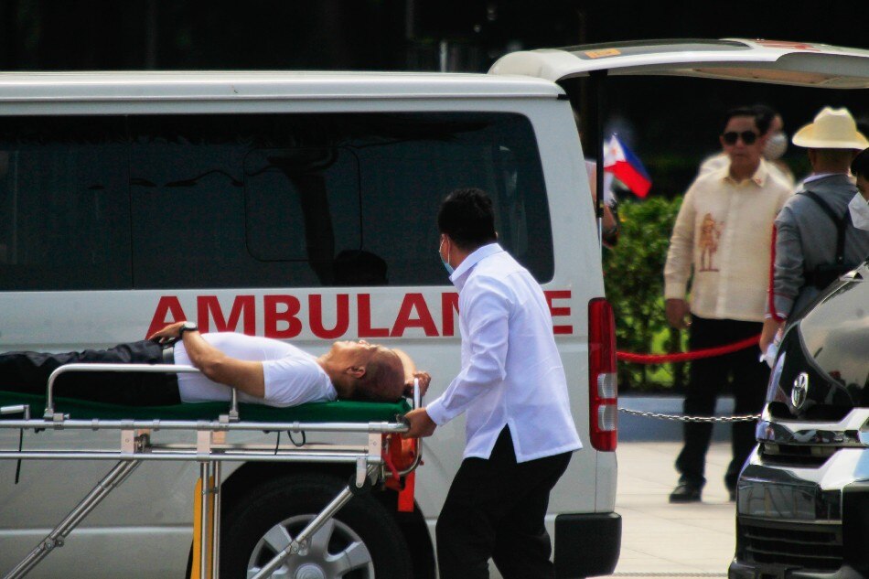 Defense Secretary Delfin Lorenzana is carried on a stretcher to an ambulance after he collapsed due to scorching heat during the Independence Day wreath-laying ceremony at the Rizal Park on Sunday, June 12, 2022. ABS-CBN News