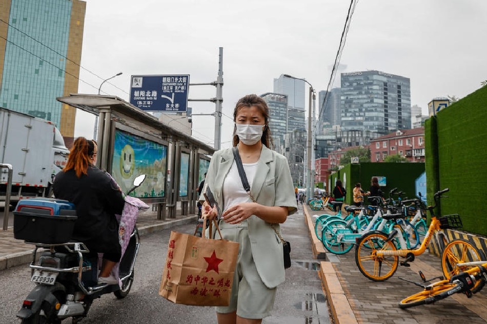 A woman wears a face mask in Chaoyang district, Beijing, China, June 13, 2022. Beijing announced 3 rounds of mass testing after a COVID-19 outbreak at a bar in Chaoyang district after the city eased restrictions. Mark R. Cristino, EPA-EFE 