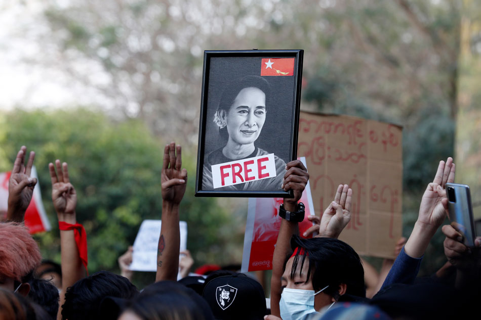 Demonstrators hold a portrait of detained State Counselor Aung San Suu Kyi while flashing the 3-finger salute, a symbol of resistance, during an anti-military protest at Hledan junction in Yangon, Myanmar, Feb. 8, 2021. Stringer, EPA-EFE