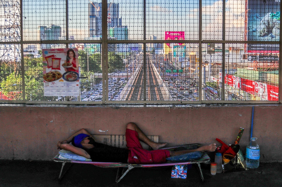 A man sleeps on a folding bed at an overpass as traffic builds up along EDSA near Kamuning Road in Quezon City on December 21, 2021. Jonathan Cellona, ABS-CBN News/file