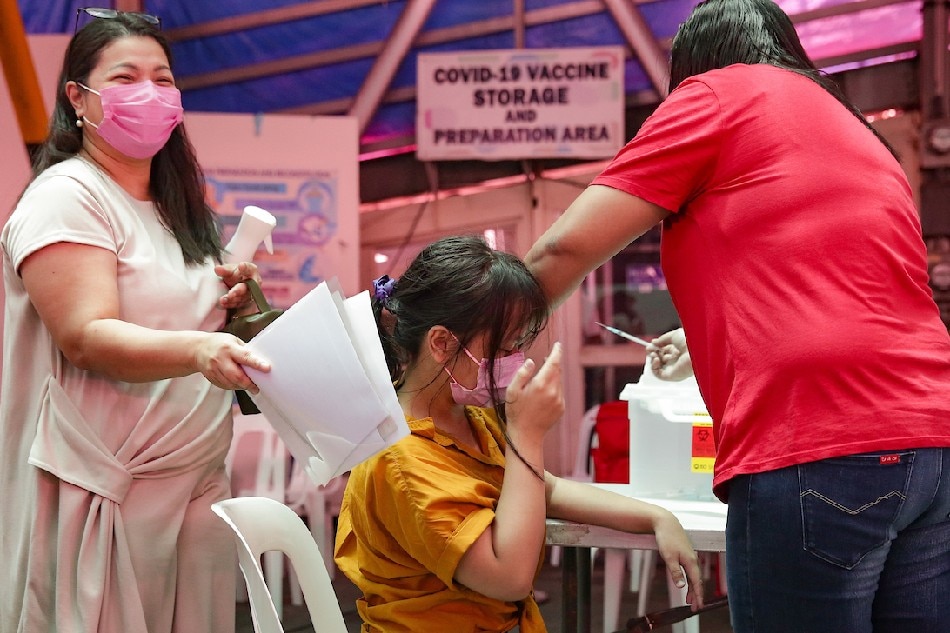 Health workers administer booster shots to minors at the Cardinal Santos Medical Center vaccination site in San Juan City on June 23, 2022. George Calvelo, ABS-CBN News