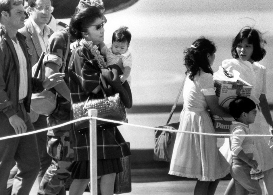 File photo dated February 26, 1986 shows Imelda Marcos (left-carrying child), wife of ousted Philippines president Ferdinand Marcos, arriving at Hickam Air Force Base from Guam following her husband's departure into exile from the Philippines. Carl Viti, AFP