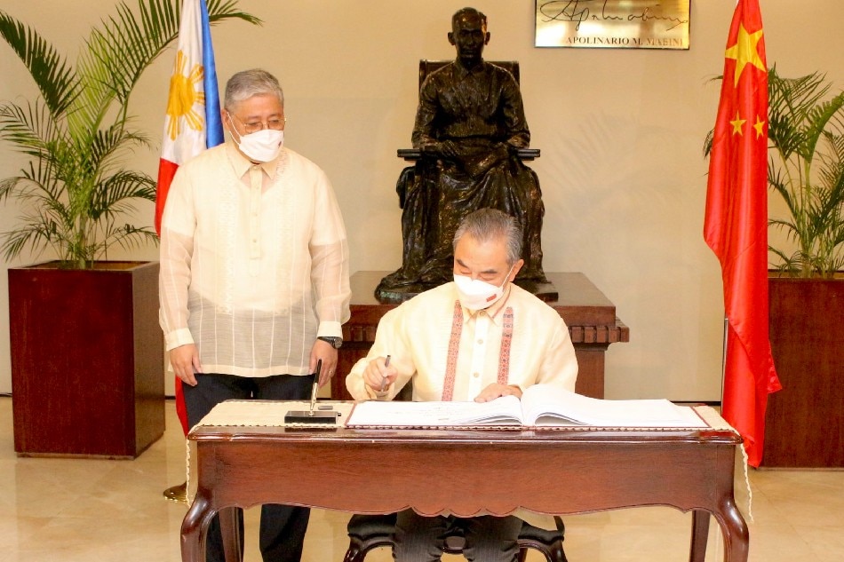Foreign Affairs Secretary Enrique Manalo looks on as SCFM Wang Yi signs the guest book in front of the Mabini statue at DFA. SCFM Wang Yi is embarking on an official visit to the Philippines. July 6, 2022/ DFA handout.
