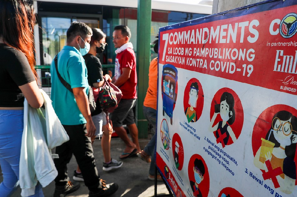 People wearing face masks as a precaution against COVID-19 fall in line at the Monumento bus stop in Caloocan on January 3, 2021. Jonathan Cellona, ABS-CBN News