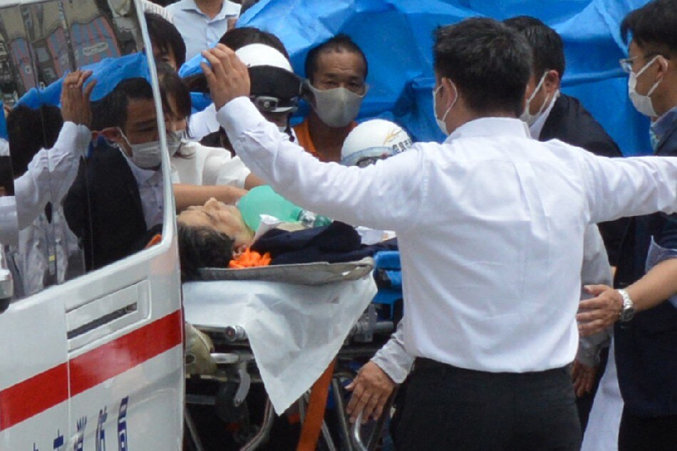Former Japanese prime minister Shinzo Abe (C) is transported into an ambulance near Yamato Saidaiji Station after being shot in the city of Nara on July 8, 2022. Shinzo Abe was shot at a campaign event on July 8, a government spokesman said, as local media reported the nation's longest-serving premier was showing no vital signs. Yomiuri Shimbun / AFP