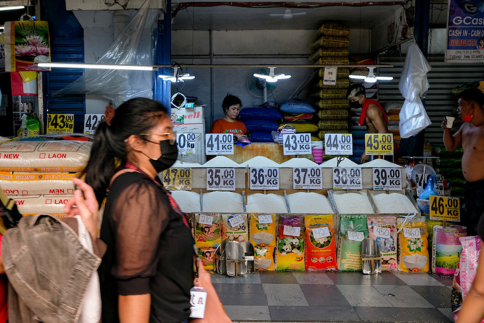 A woman passes by a rice stall at the Pasig City Mega Market on July 5, 2022. George Calvelo, ABS-CBN News