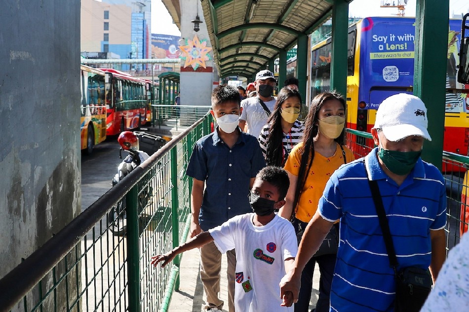 People wearing face masks as a precaution against COVID-19 fall in line at the Monumento bus stop in Caloocan on January 3, 2021. Jonathan Cellona, ABS-CBN News