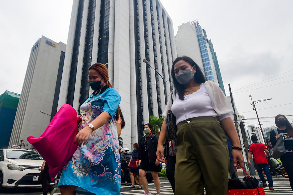 Pedestrians walk at a crossing in Makati City on July 12, 2022. Mark Demayo, ABS-CBN News/file