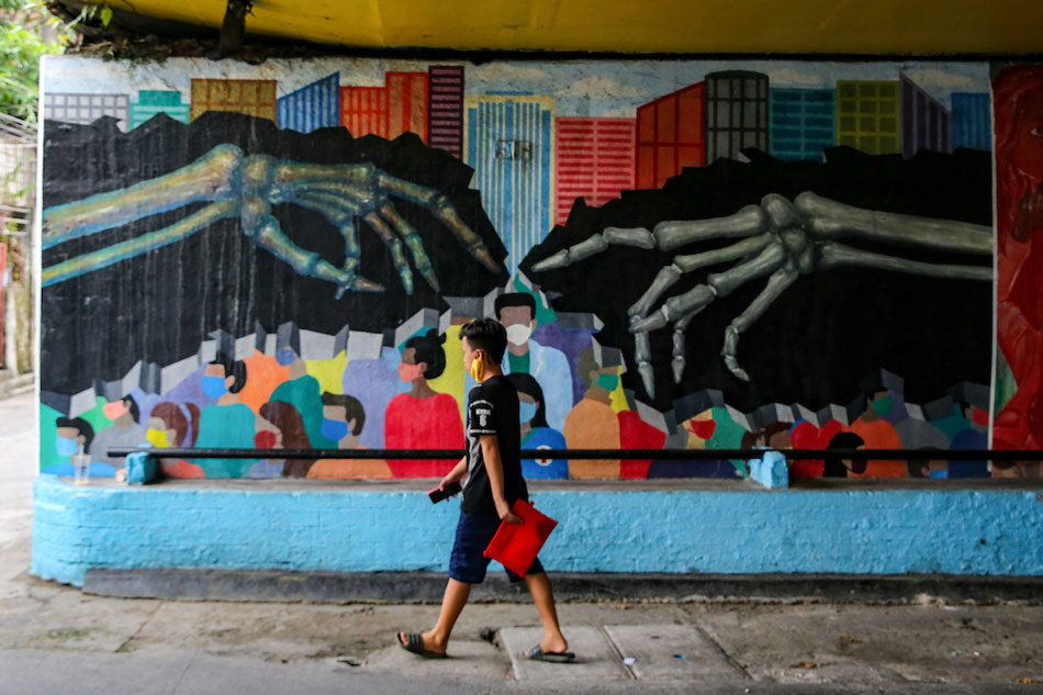  A man walks past a COVID-19 pandemic-themed mural at an underpass in Makati CIty on July 18, 2022. Jonathan Cellona, ABS-CBN News