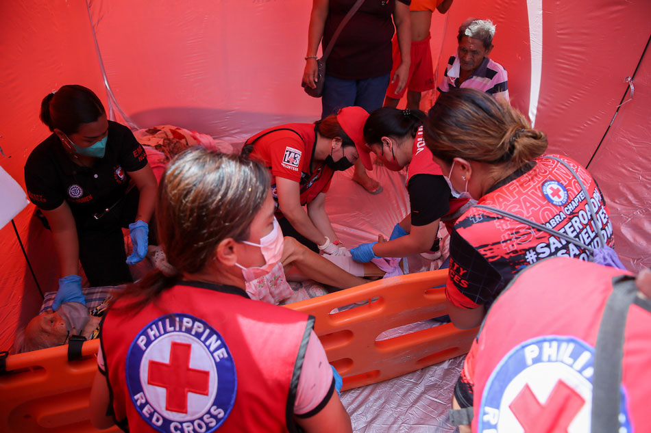 Volunteers of the Philippine Red Cross-Abra Chapter attend to an elderly woman suffering from a suspected fracture at the Abra Provincial Capitol grounds on July 28, 2022. Jonathan Cellona, ABS-CBN News
