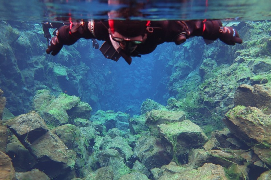 This handout picture taken underwater shows a snorkeller observing the fissure underwater on July 26, 2022 in Thingvellir, Iceland. Located between the North American and Eurasian tectonic plates, at the bend of two continents, the Silfra Rift in Iceland is one of the most famous dive sites in the world, popular with tourists who venture into its icy waters every summer. Thomas Gov, Agence France-Presse