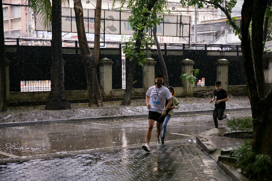 Volunteers under the rain run at the University of Santo Tomas (UST) on May 20, 2022. George Calvelo, ABS-CBN News/file